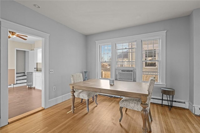 office area with light hardwood / wood-style floors, baseboard heating, ceiling fan, and cooling unit