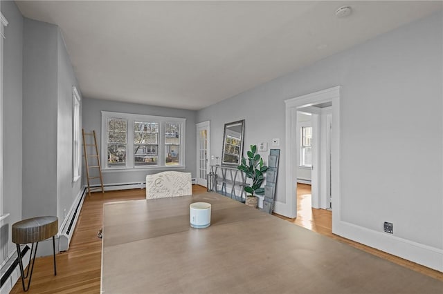 dining space featuring wood-type flooring and baseboard heating