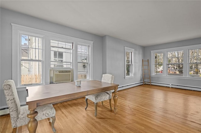 dining area featuring wood-type flooring, a baseboard heating unit, a wealth of natural light, and cooling unit