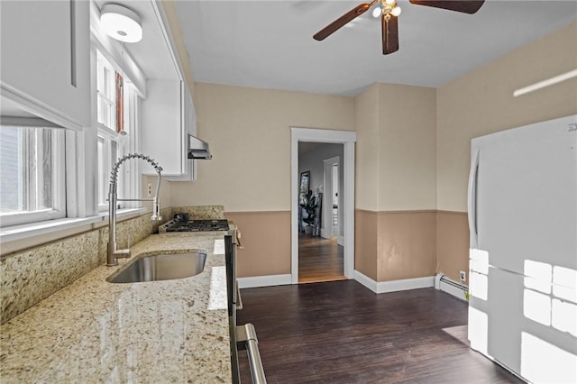 kitchen with plenty of natural light, light stone counters, dark wood-type flooring, and a baseboard radiator