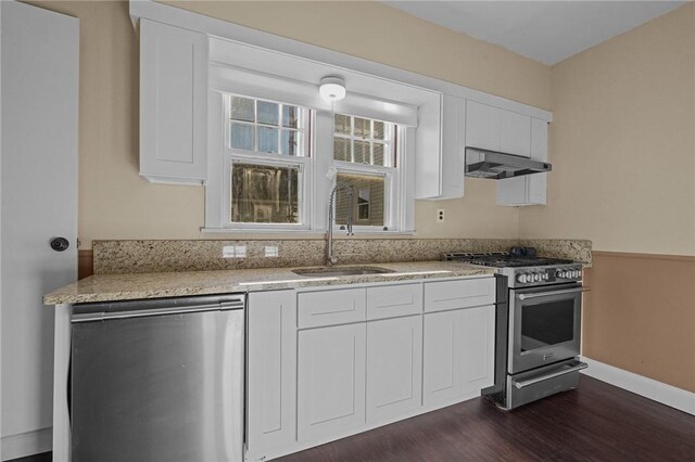 kitchen featuring dark wood-type flooring, sink, light stone countertops, white cabinetry, and stainless steel appliances