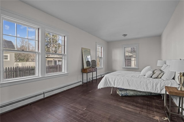 bedroom featuring dark hardwood / wood-style floors and a baseboard heating unit