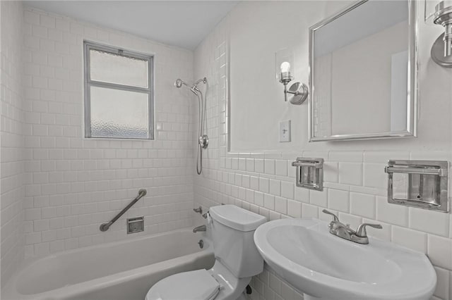 full bathroom featuring backsplash, sink, tiled shower / bath combo, toilet, and tile walls