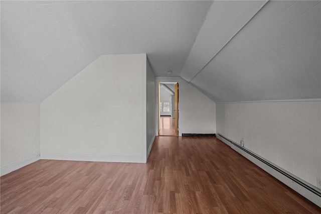 additional living space with hardwood / wood-style floors, a baseboard radiator, and vaulted ceiling