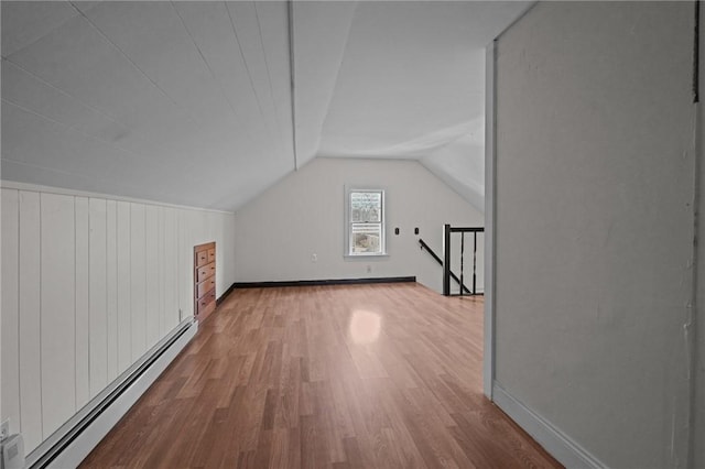 additional living space featuring light hardwood / wood-style flooring, baseboard heating, and lofted ceiling