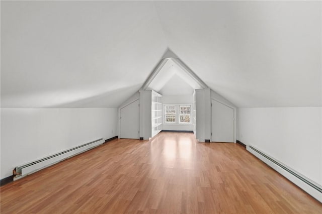 bonus room featuring vaulted ceiling, light hardwood / wood-style flooring, and a baseboard heating unit