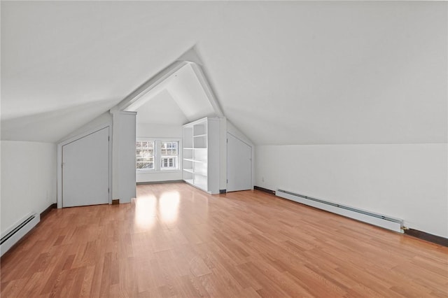 additional living space with light hardwood / wood-style flooring, baseboard heating, and lofted ceiling