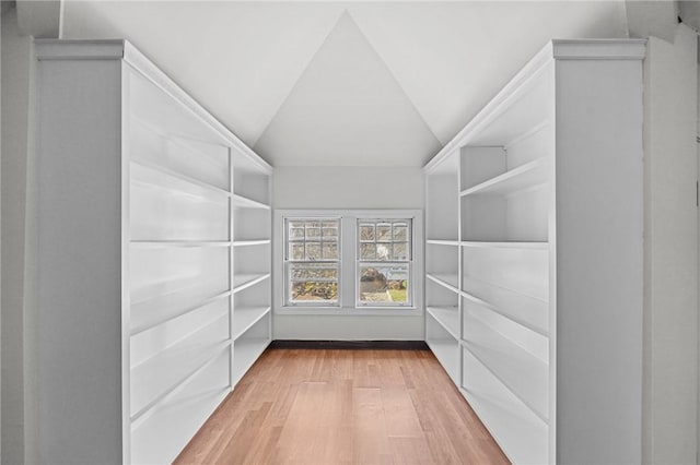 walk in closet featuring light hardwood / wood-style flooring and vaulted ceiling