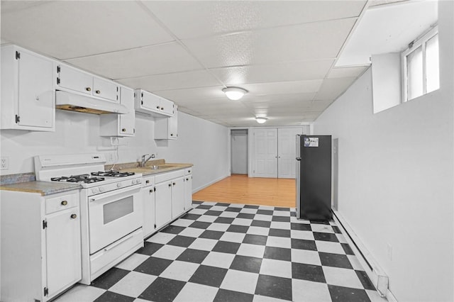 kitchen with white cabinets, stainless steel refrigerator, gas range gas stove, and sink