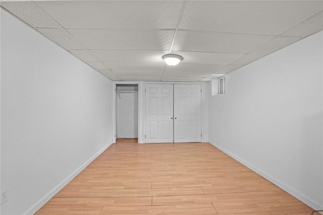 unfurnished bedroom with a closet, light hardwood / wood-style floors, and a drop ceiling