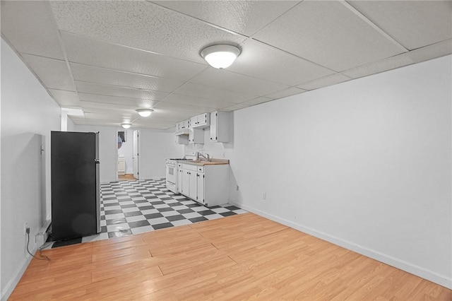 basement featuring a drop ceiling and wood-type flooring