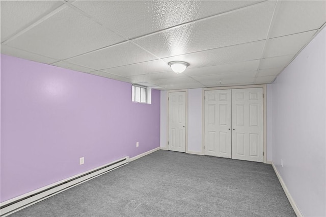 unfurnished bedroom with a paneled ceiling, carpet, and a baseboard radiator