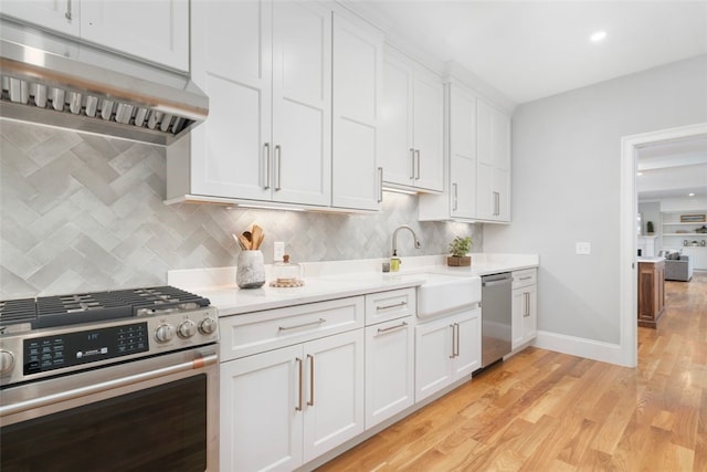 kitchen featuring white cabinets, sink, appliances with stainless steel finishes, and light hardwood / wood-style flooring