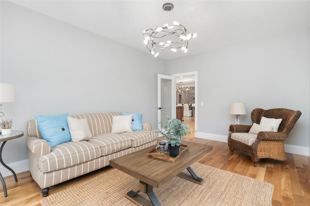 living room featuring a chandelier and light hardwood / wood-style floors