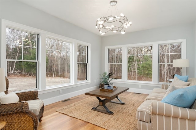 sunroom / solarium with a healthy amount of sunlight and an inviting chandelier