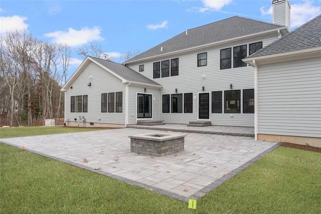 rear view of property with a yard, an outdoor fire pit, and a patio area