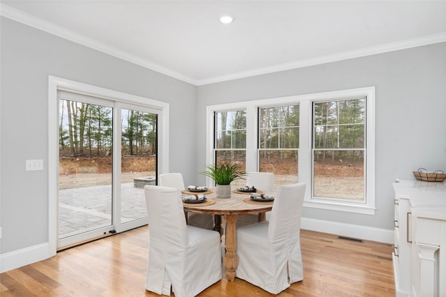 dining space featuring light hardwood / wood-style floors and ornamental molding