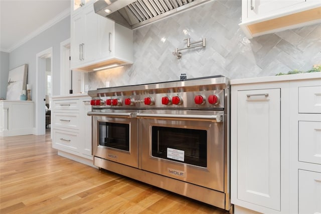 kitchen with light wood-type flooring, tasteful backsplash, ornamental molding, double oven range, and white cabinets