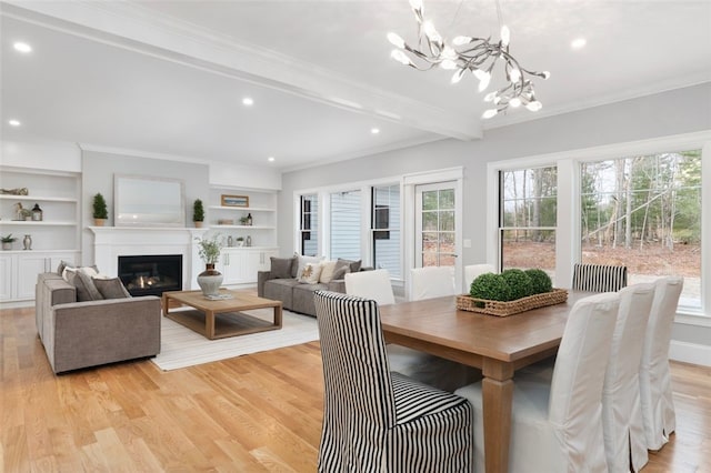 dining area featuring a healthy amount of sunlight, light wood-type flooring, beam ceiling, and a chandelier