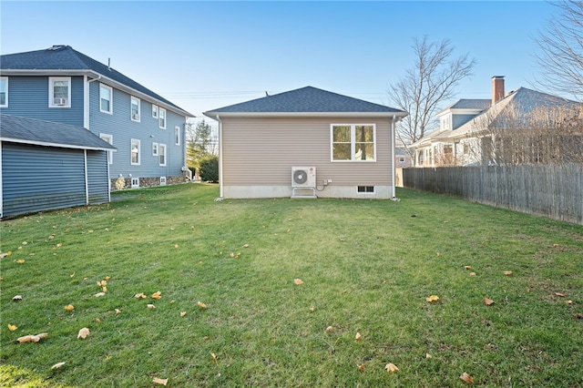 rear view of property featuring ac unit, fence, and a yard