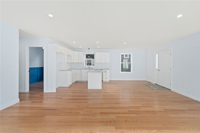 interior space featuring recessed lighting, baseboards, and light wood finished floors