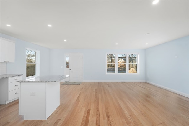 interior space with light wood-type flooring, white cabinetry, and a wealth of natural light