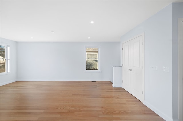 spare room with light wood-type flooring, baseboards, and recessed lighting