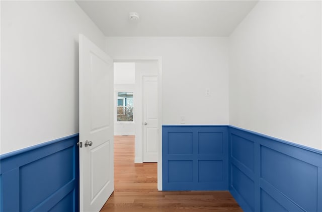 corridor featuring wainscoting and wood finished floors