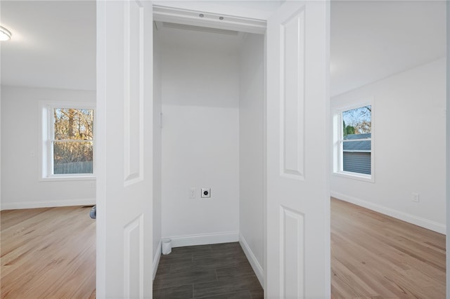 interior space with laundry area, baseboards, electric dryer hookup, and wood finished floors