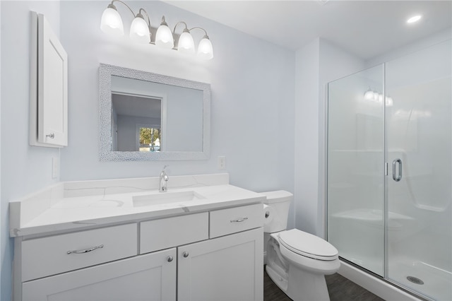 full bath featuring a stall shower, vanity, and toilet