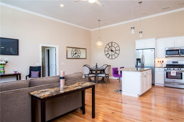 living room with ceiling fan, light hardwood / wood-style floors, and ornamental molding