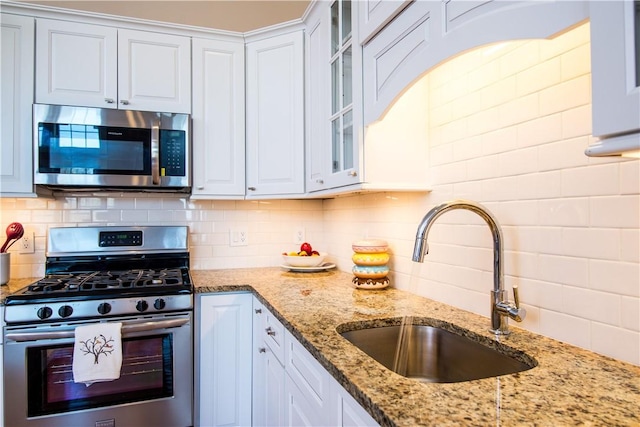 kitchen with sink, white cabinetry, stainless steel appliances, and tasteful backsplash