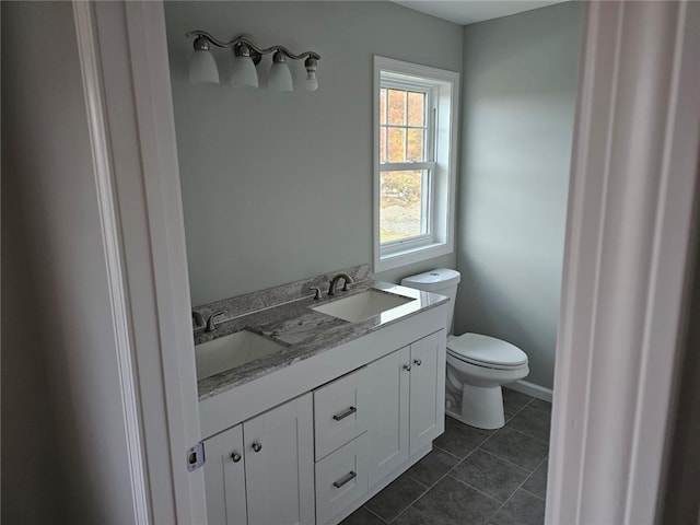 bathroom with toilet, vanity, and tile patterned floors