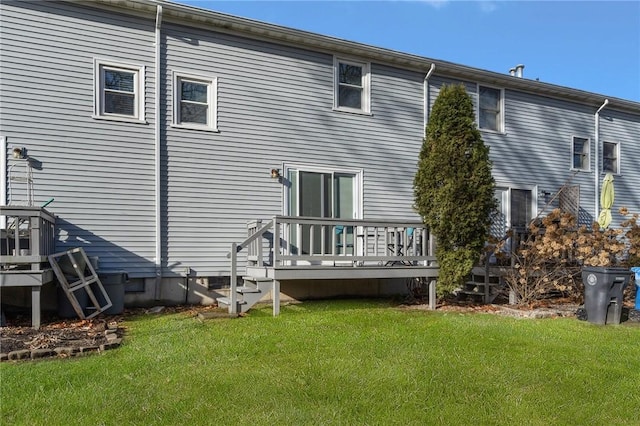 rear view of house featuring a deck and a yard