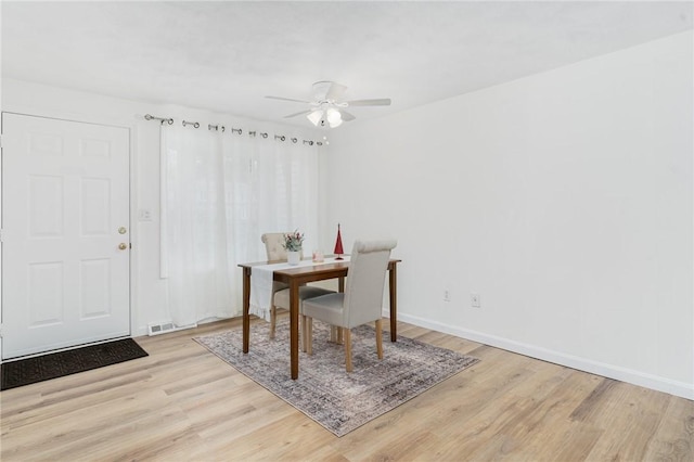 dining area with light wood-type flooring and ceiling fan