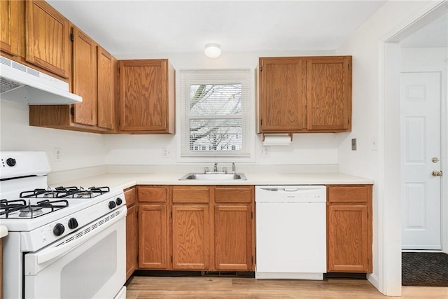 kitchen featuring sink, white appliances, and light wood-type flooring