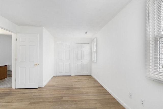 hallway featuring plenty of natural light and light wood-type flooring