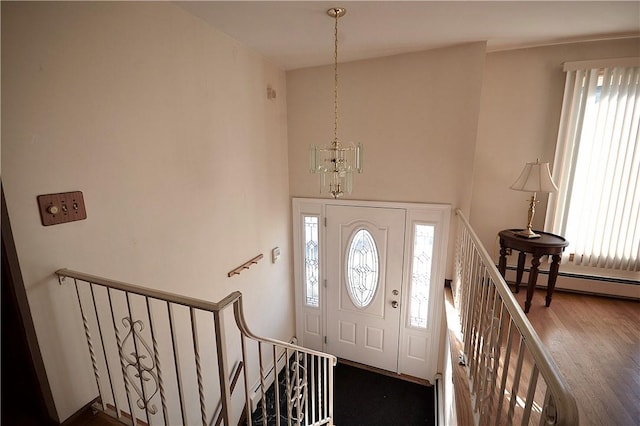 entryway featuring hardwood / wood-style floors, a baseboard radiator, and an inviting chandelier