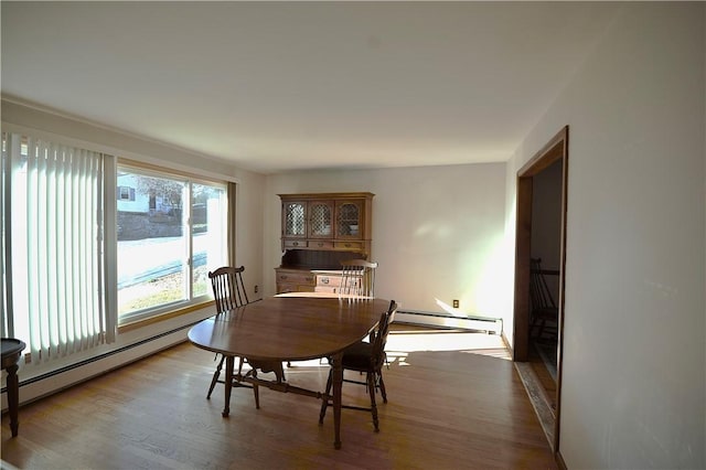 dining room with a baseboard heating unit and hardwood / wood-style floors