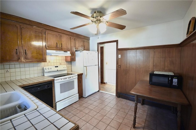 kitchen featuring black appliances, tile counters, ceiling fan, backsplash, and sink