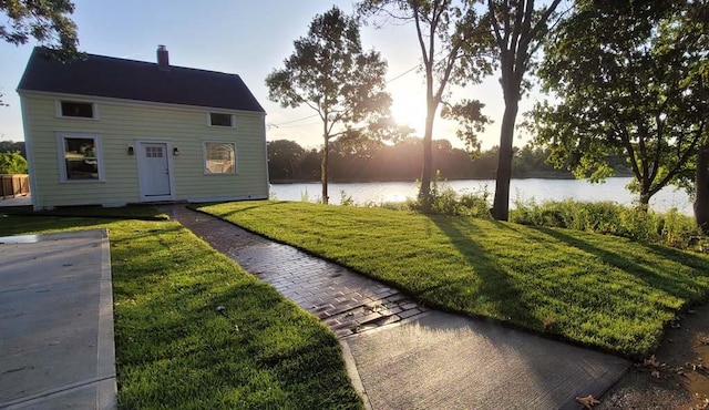 view of front of property featuring a yard and a water view