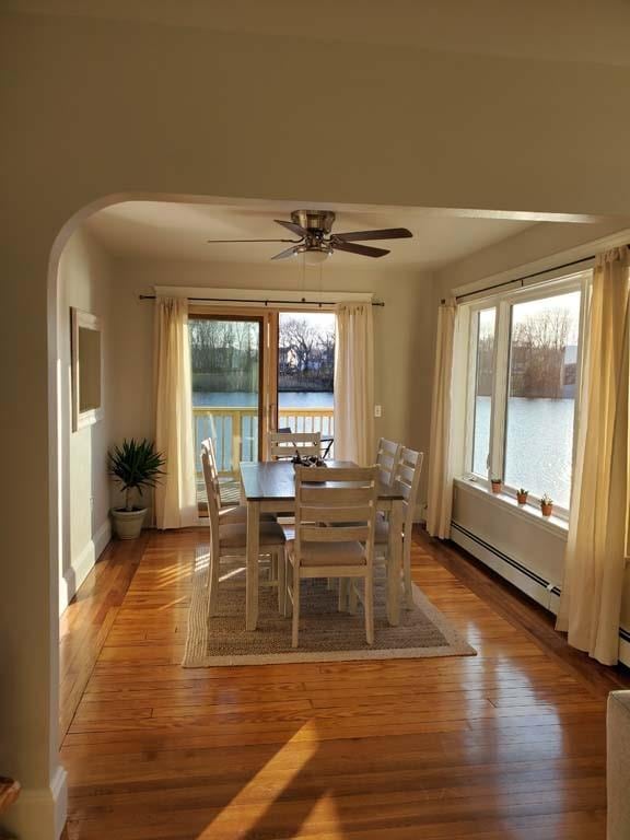 unfurnished dining area featuring ceiling fan, plenty of natural light, and light hardwood / wood-style flooring