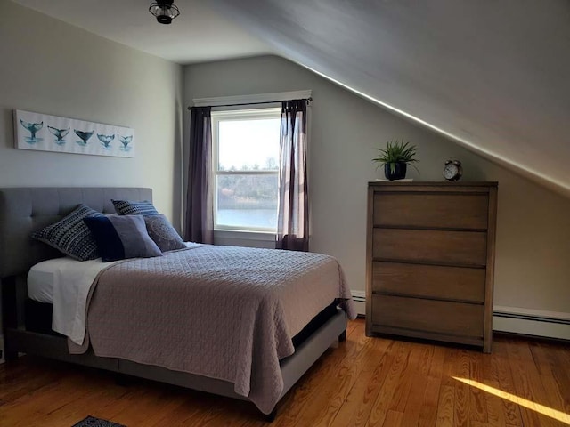 bedroom featuring light wood-type flooring, a baseboard radiator, and vaulted ceiling