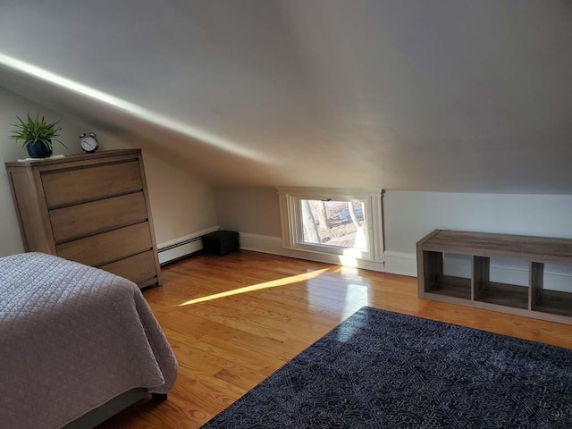 bedroom with a baseboard radiator, light hardwood / wood-style floors, and lofted ceiling