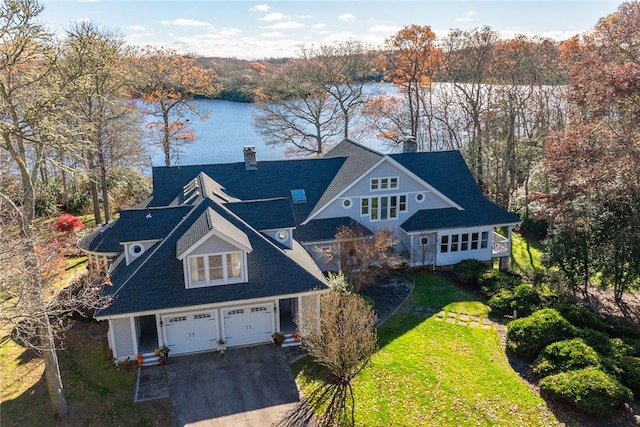 view of front of property with a front yard, a water view, and a garage