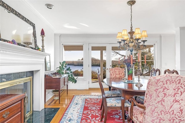 dining space with a wealth of natural light, crown molding, and a chandelier