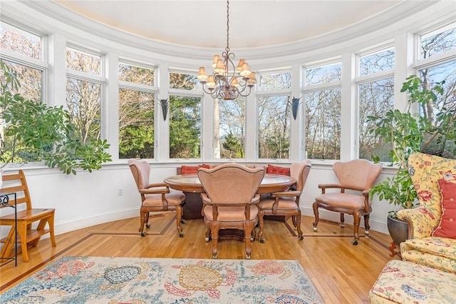 sunroom / solarium featuring a healthy amount of sunlight and a notable chandelier