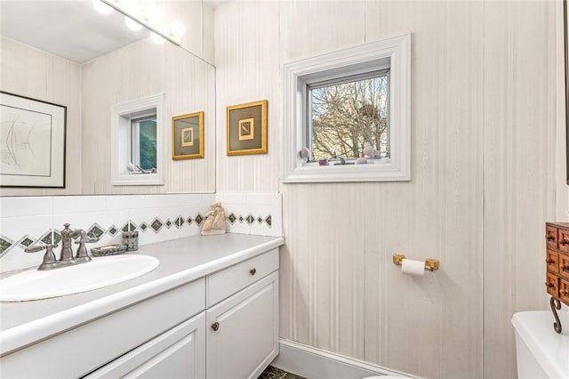 bathroom with tasteful backsplash, vanity, and toilet