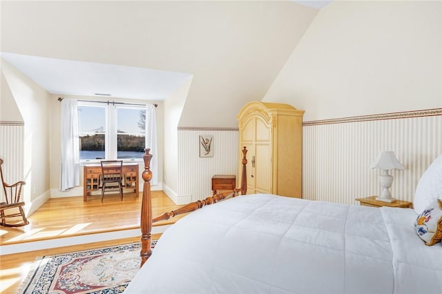 bedroom with light wood-type flooring and lofted ceiling