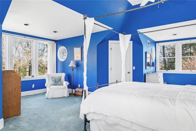 bedroom with carpet flooring, multiple windows, and lofted ceiling